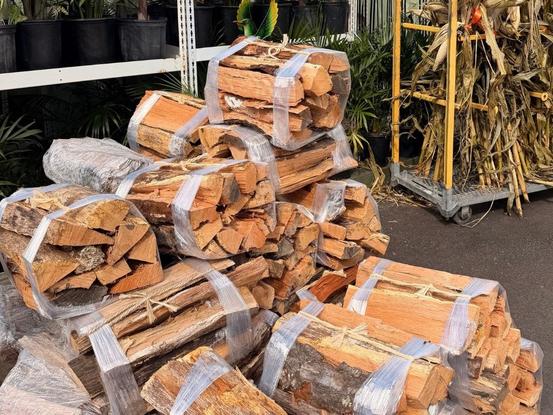 Stacks of bundled firewood beside corn stalks
