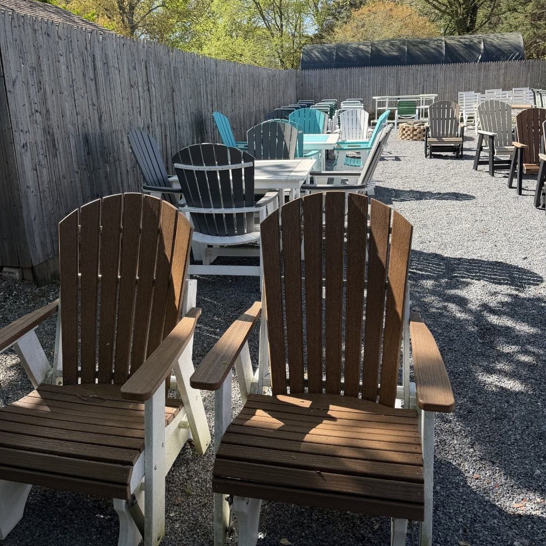 Rows of Adirondack chairs and outdoor tables in the side yard