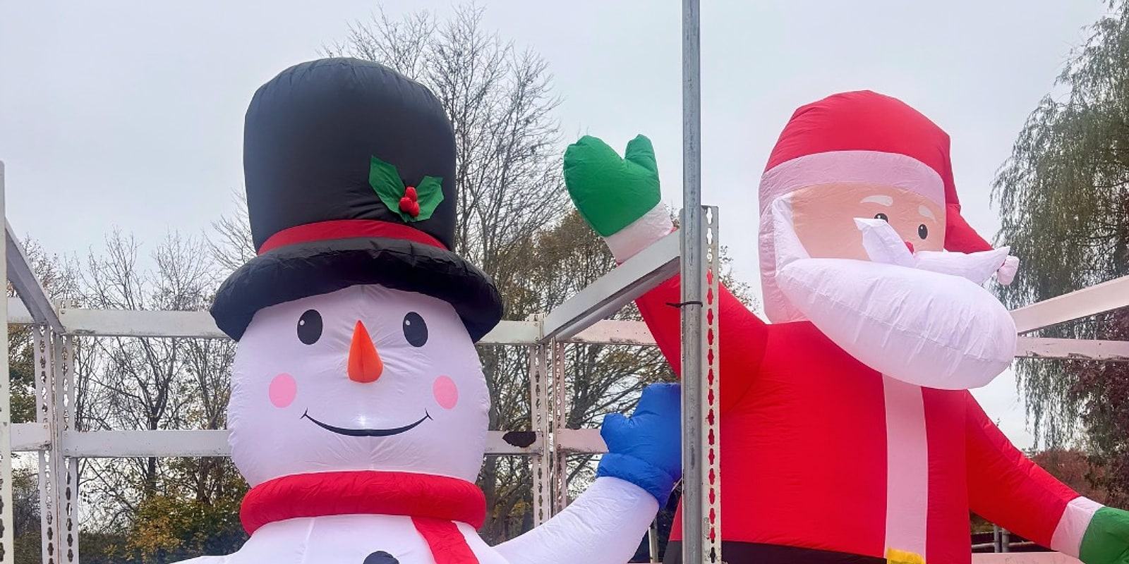 An inflatable snowman and Santa set up outside the stand