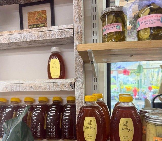 Local honey and 4 Corners pickles on wooden shelves